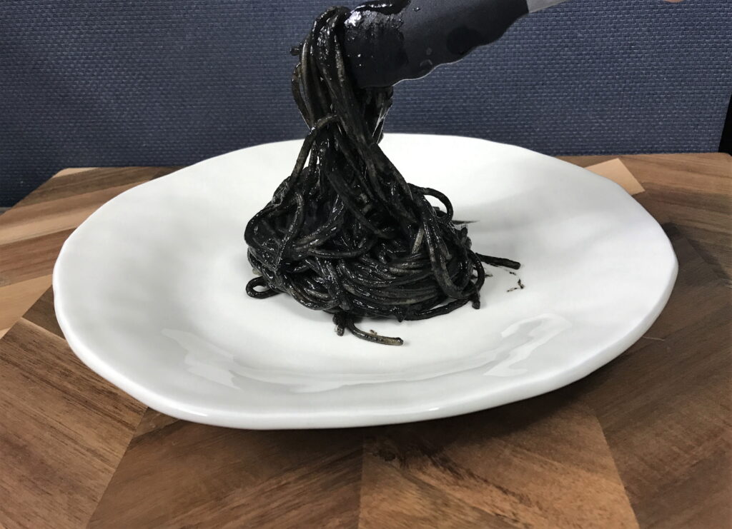いかすみパスタをお皿に盛りつける
