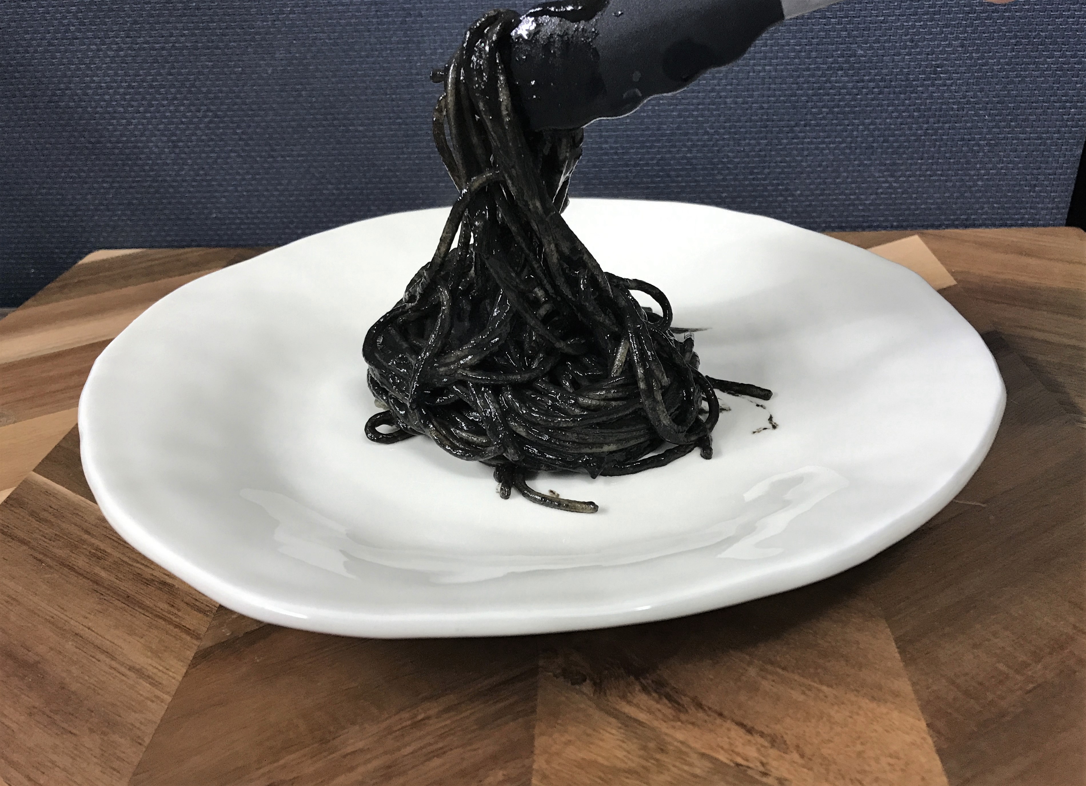 いかすみパスタをお皿に盛りつける
