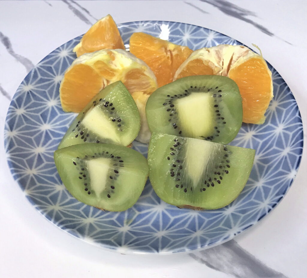 お皿に盛りつけられたキウイフルーツとオレンジ