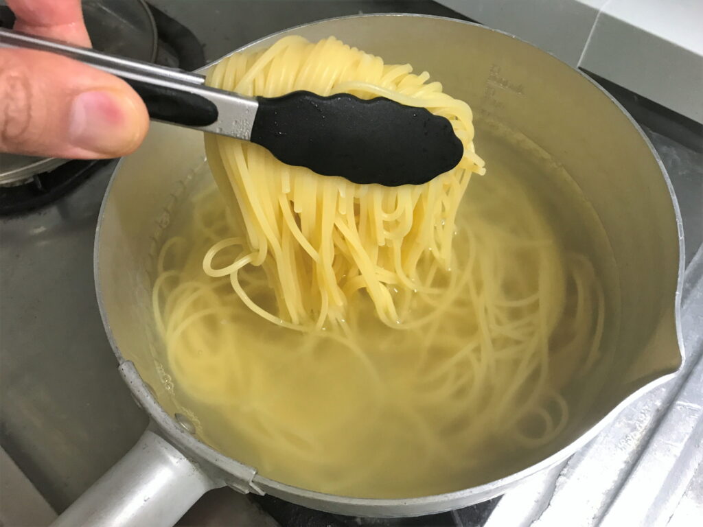 アルミ鍋で茹でたスパゲッティをトングでつかむ02
