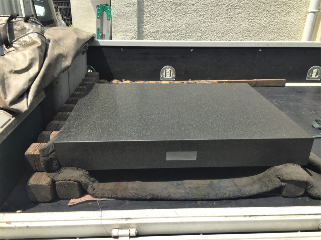 トラックに積まれた黒御影石の定盤