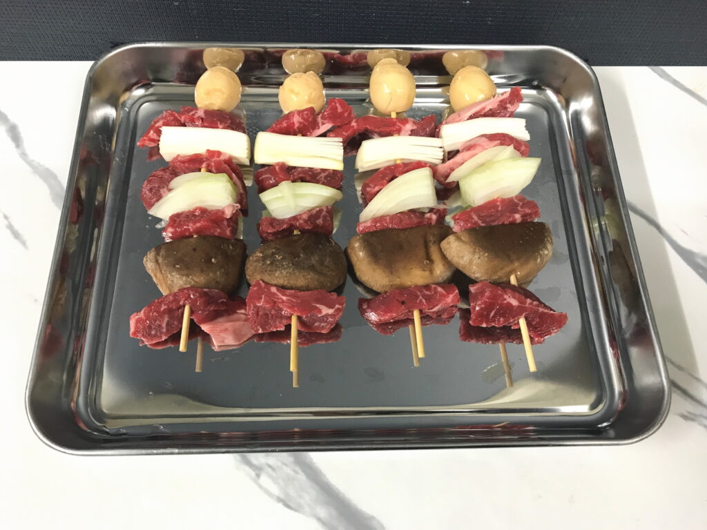 鉄板焼き用のシイタケとネギと煮卵と牛ロースの串焼き