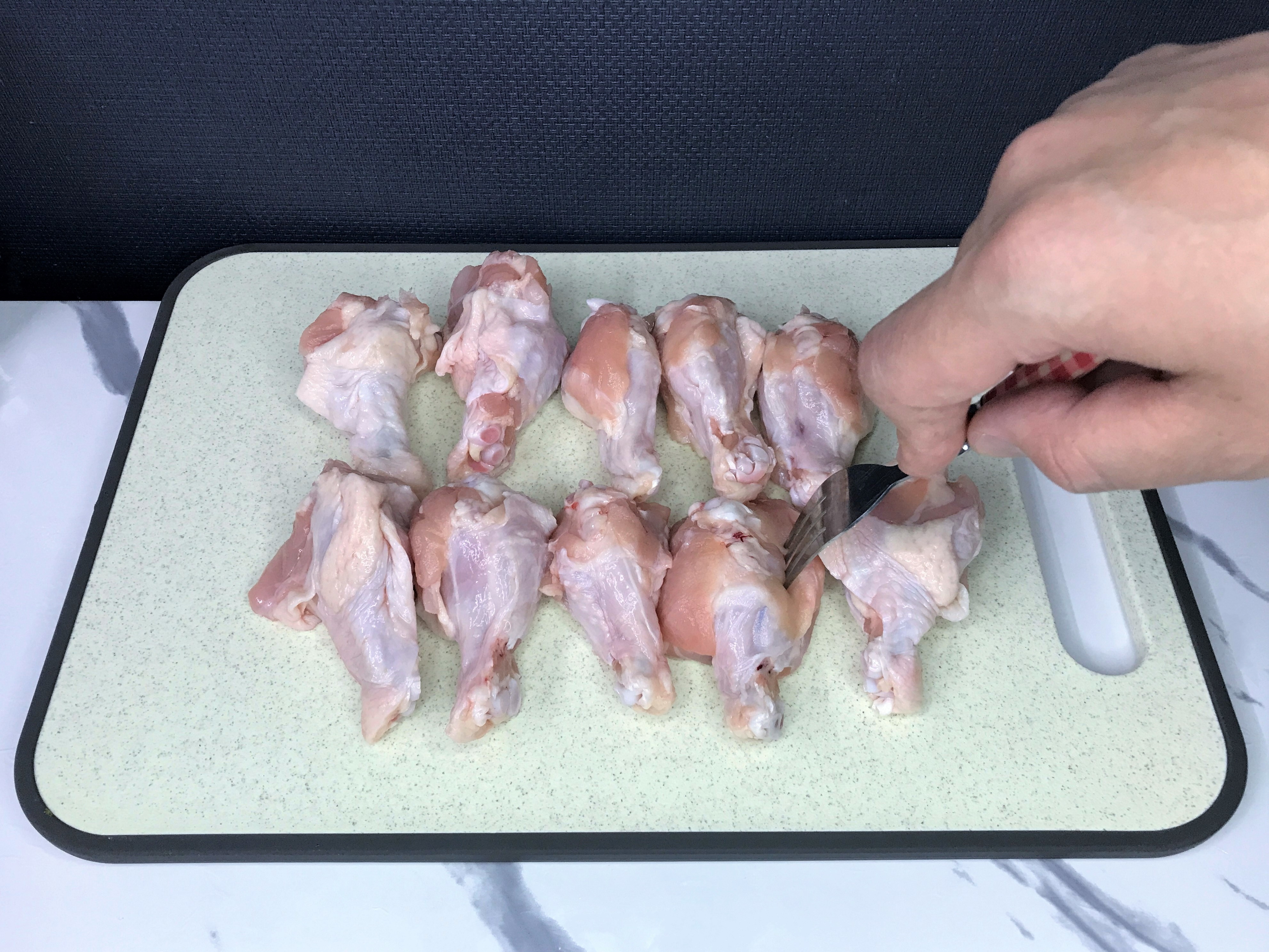鶏の手羽元にフォークを刺して下処理