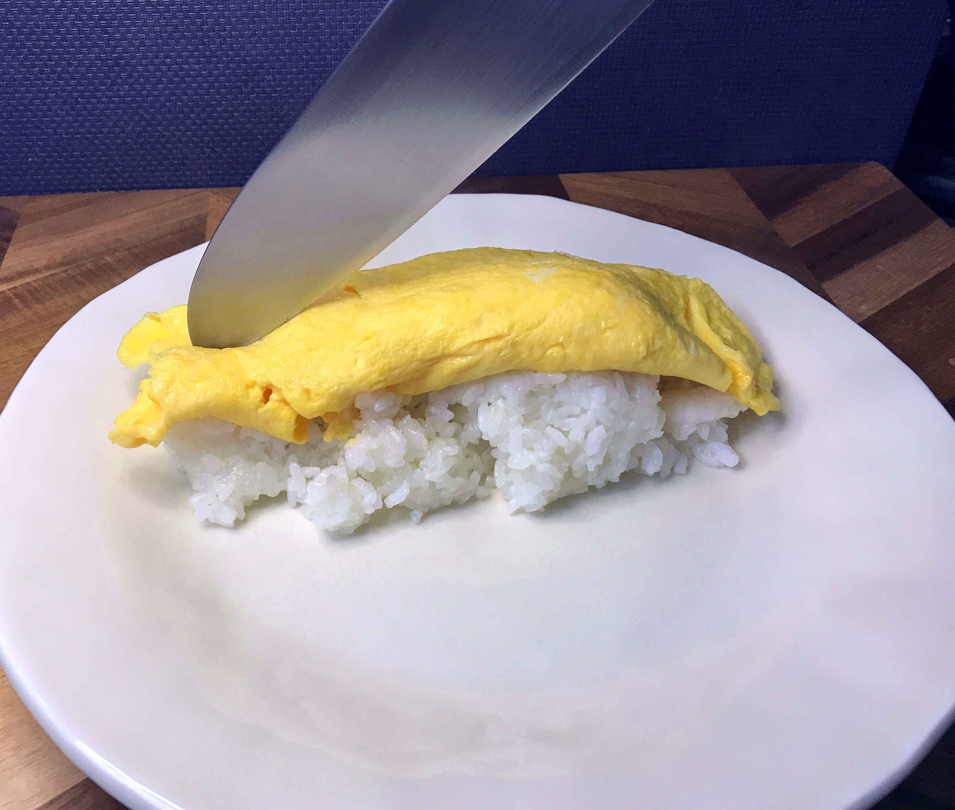 ごはんに乗せた半熟のふわとろ玉子を包丁で割る