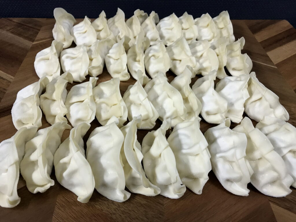まな板に並べられた沢山の冷凍餃子