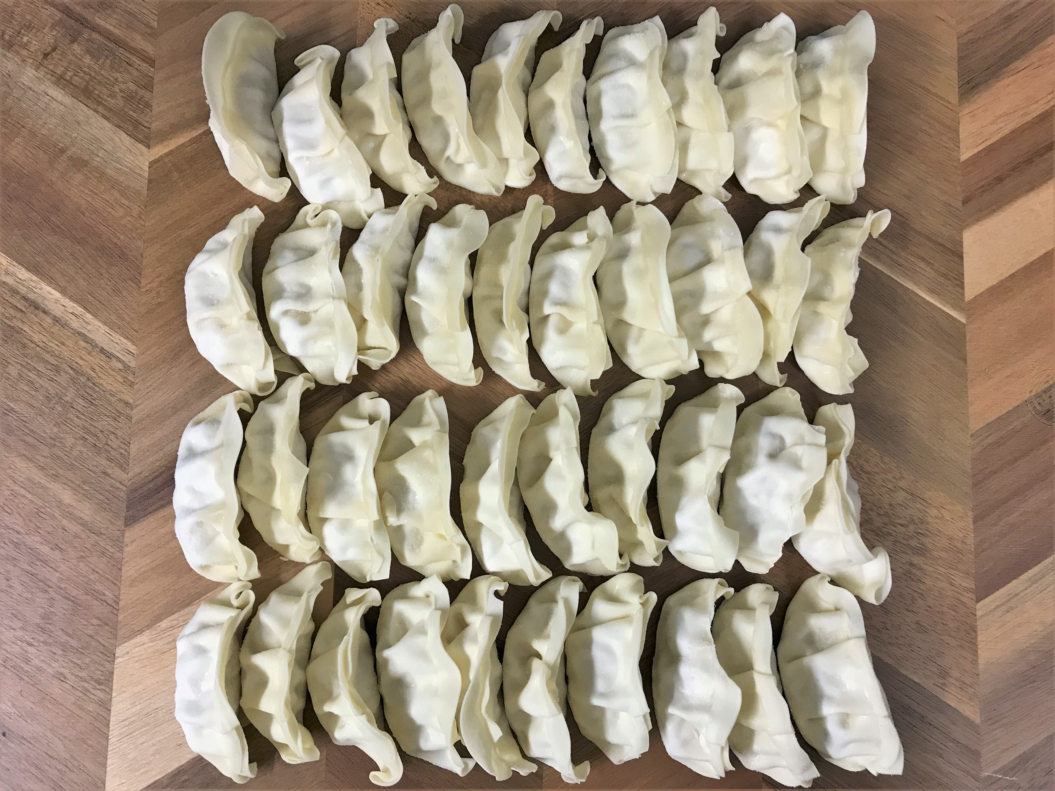 まな板に並べられた沢山の冷凍餃子02