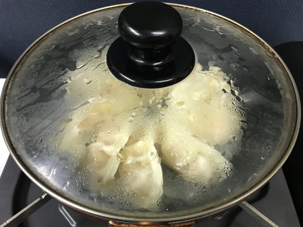 冷凍餃子をフタをしたフライパンで蒸し焼きにする