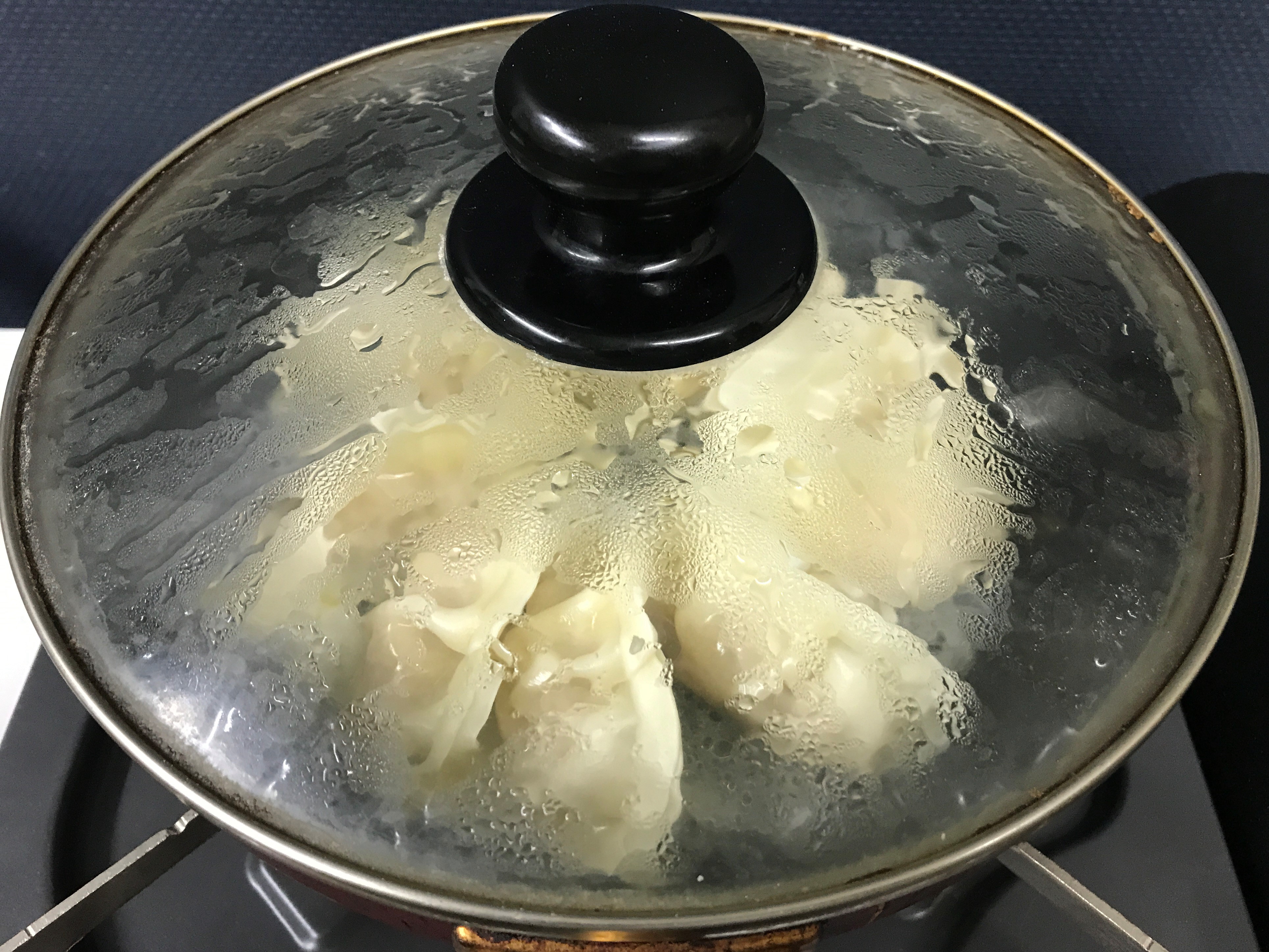 冷凍餃子をフタをしたフライパンで蒸し焼きにする